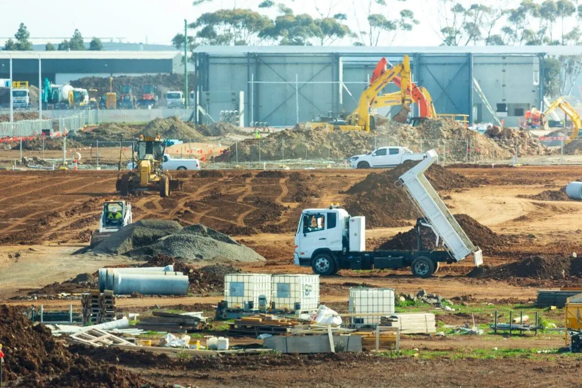 Construction site with trucks and construction equipment. Fixed Price building contract in construction