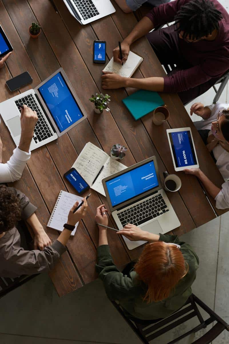 Photo Of People Sitting Near Wooden Table drafting a Business Plan