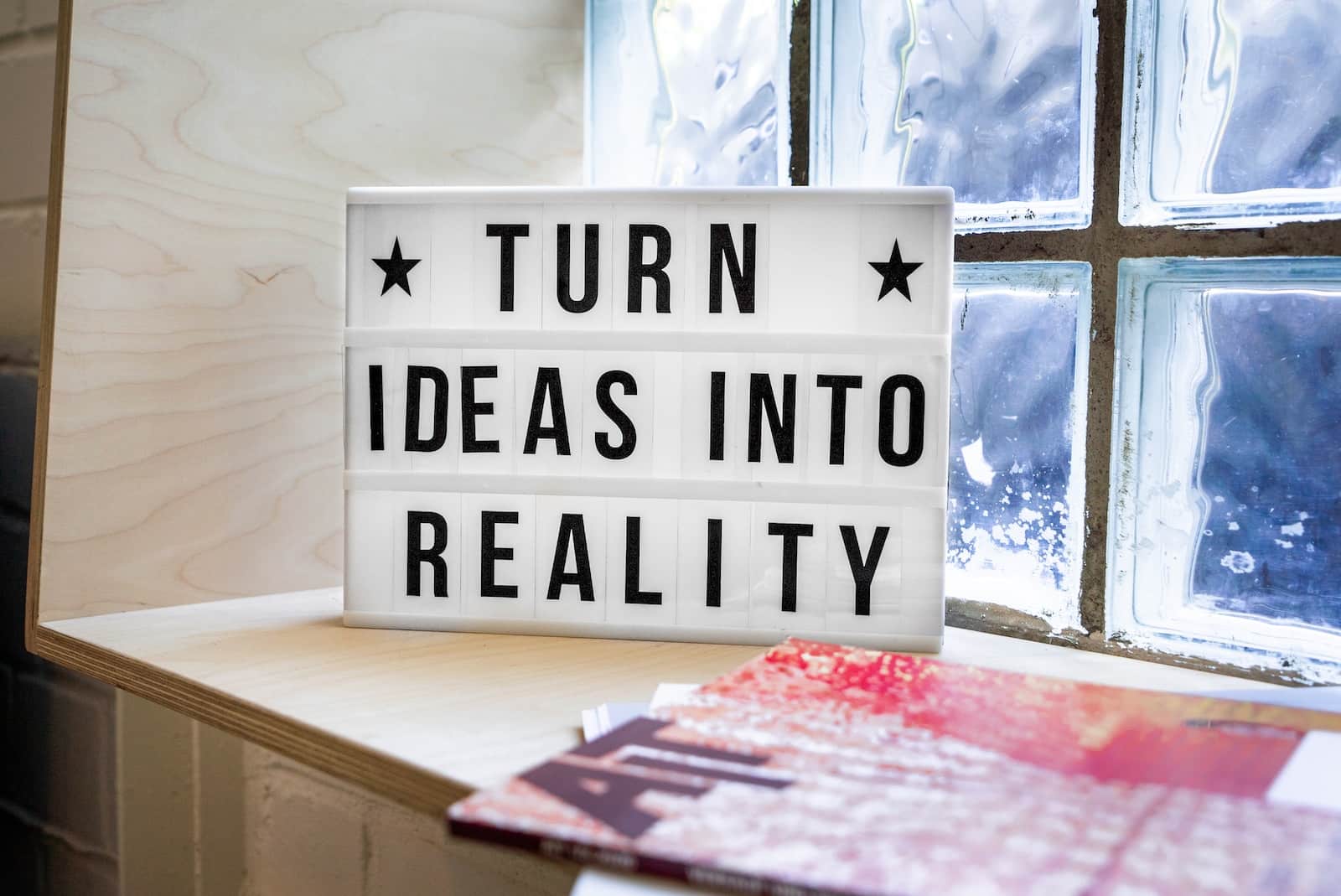 Startups. Turn ideas into reality - white and black wooden quote board. Blaze Business & Legal.
