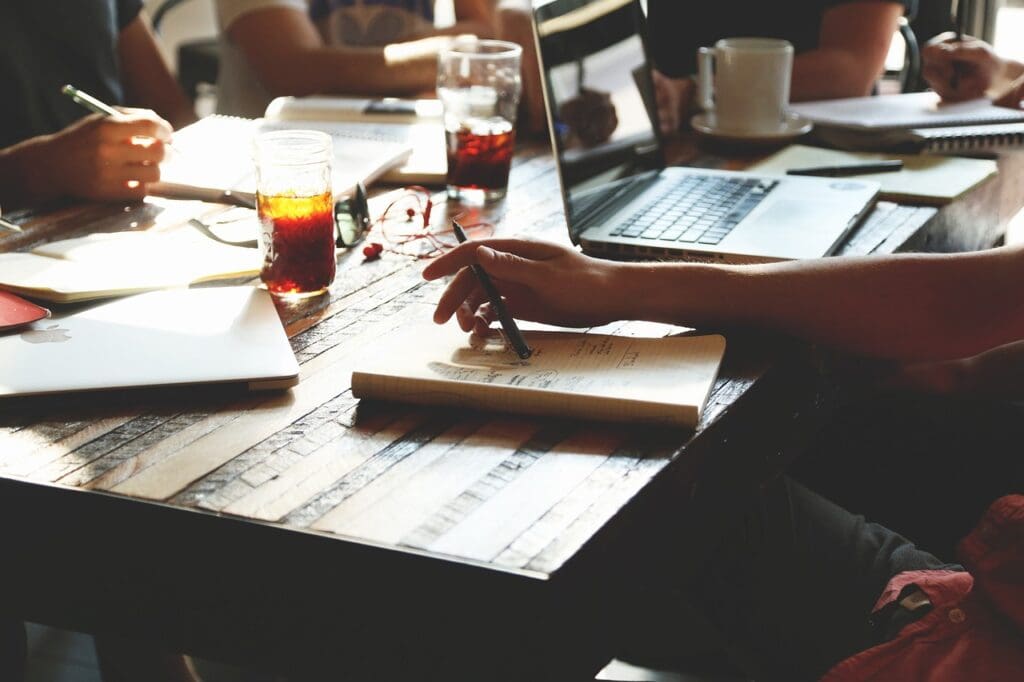 Business Consultant and client sitting at table with papers spread out. Small Business Management Consulting