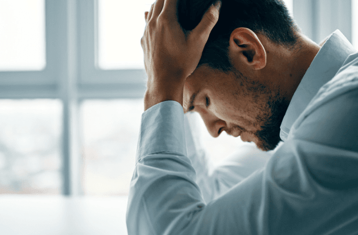 Man with his head in his hands. How to improve your cash flow in Brisbane