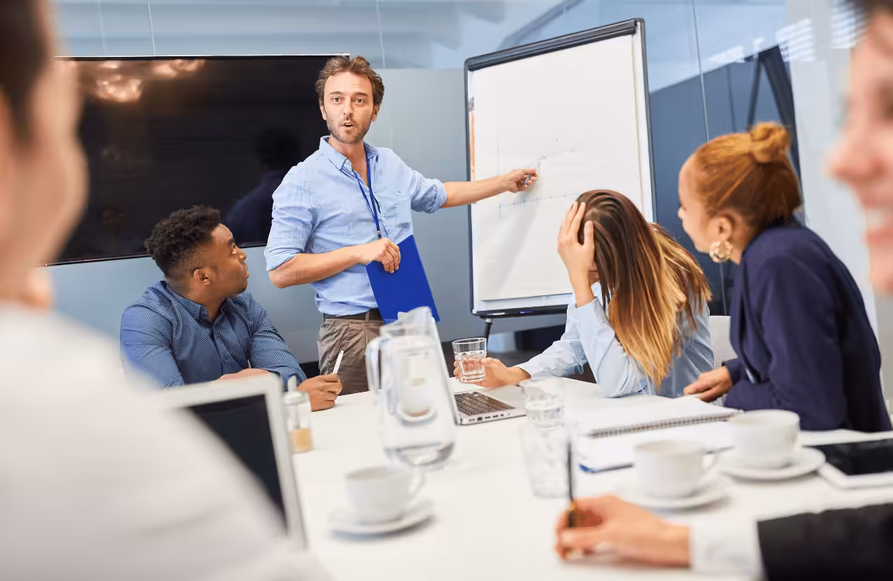 Man standing beside the whiteboard during his presentation. Business Growth Consultant. Services. Blaze Business & Legal