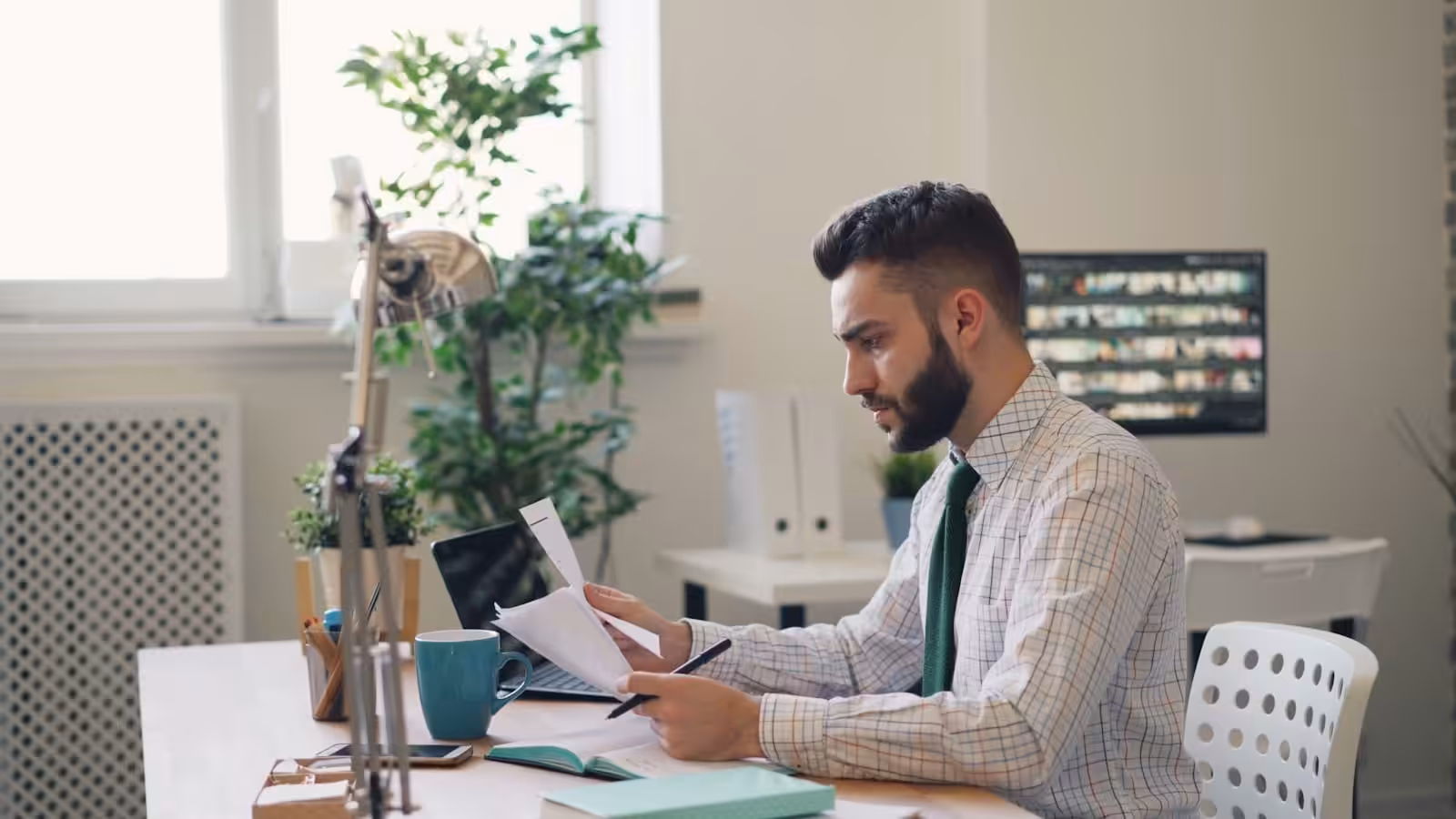 A Contracts Lawyer sitting at a desk with a laptop and pages from a contract