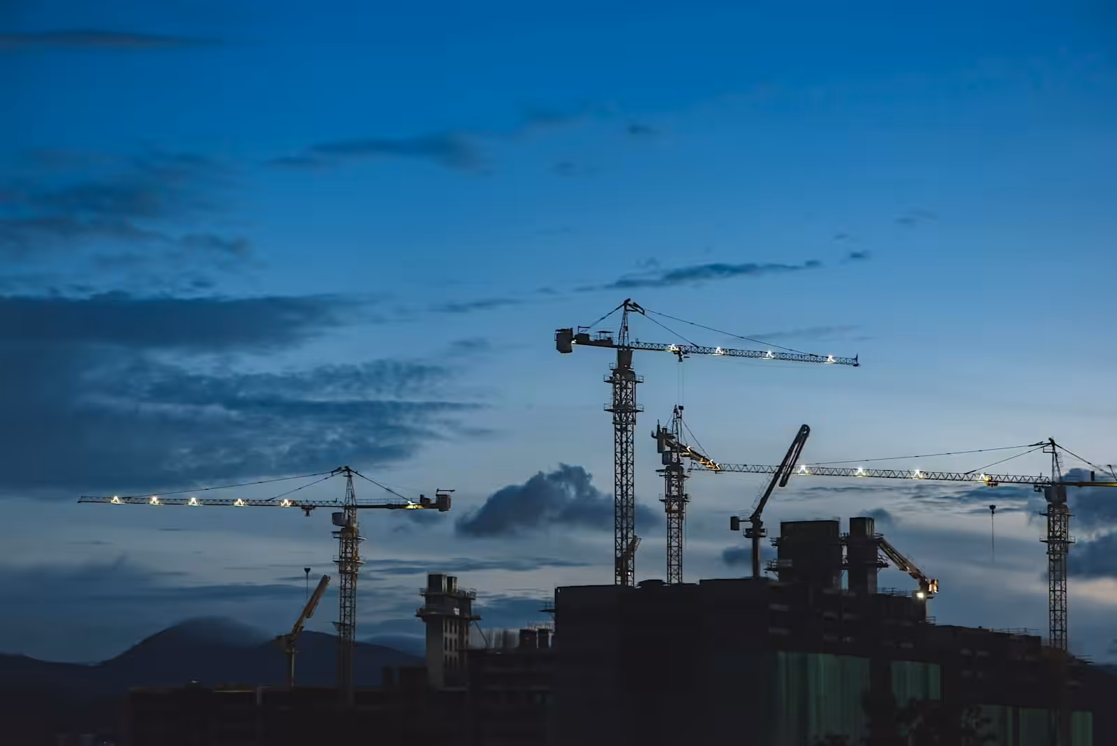 Cranes on a construction site above a building. Understanding the construct only contract. Construction Lawyer