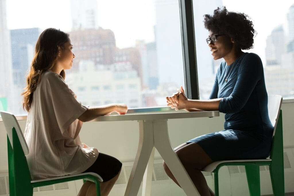 How We Help You | Blaze Business & Legal 1 Two women sitting at a table and talking. Blaze Business & Legal - How we help you. Tips for engaging a Business Lawyer
