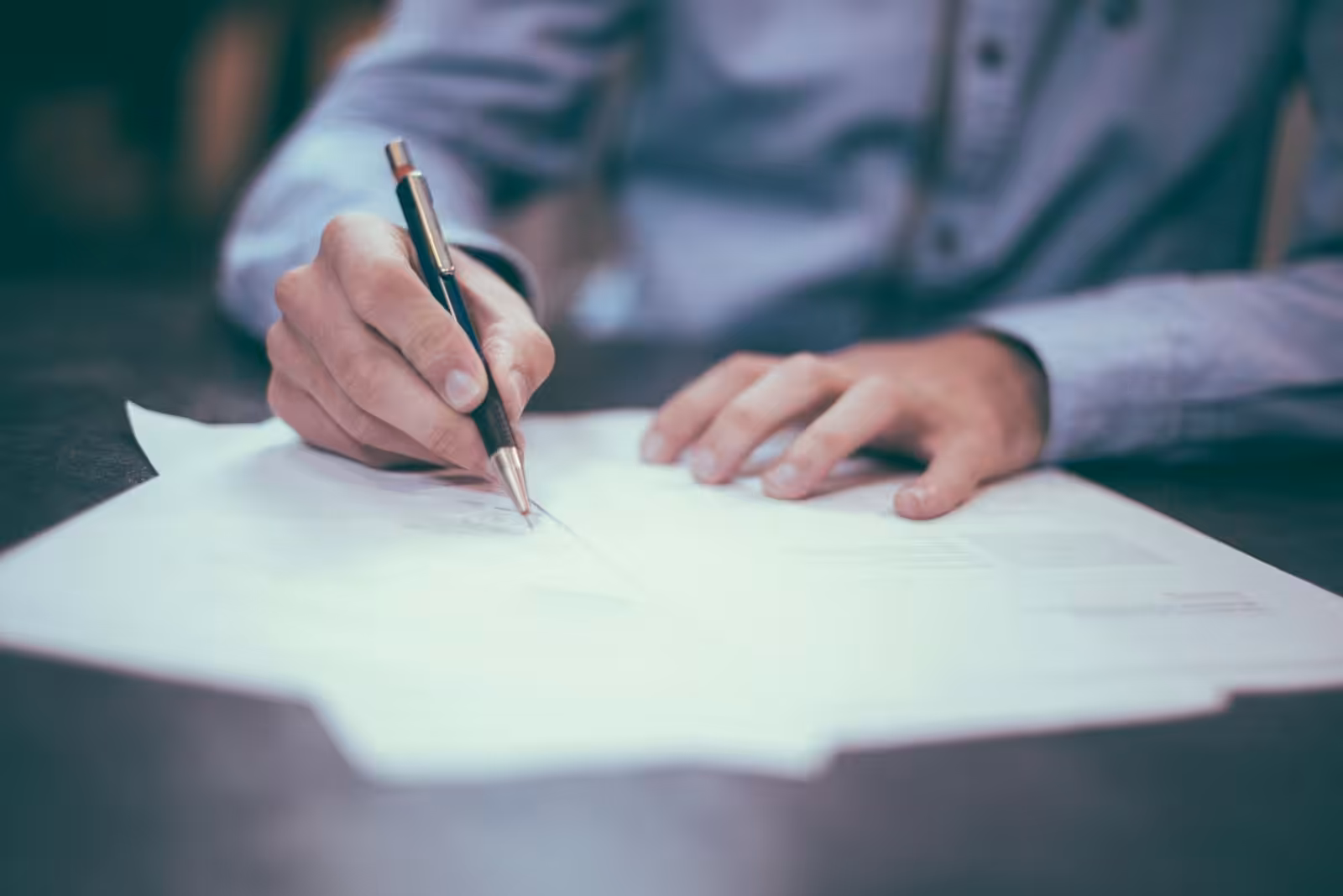Man signing a contract. Building Contract Law. Blaze Business & Legal