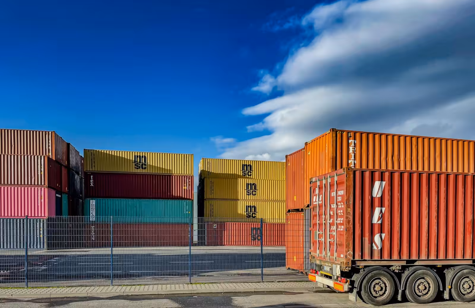 A truck is parked in front of a bunch of shipping containers. How to improve contracting in your business. Medium business. Construction Lawyer. AS2124-1992. AS2124