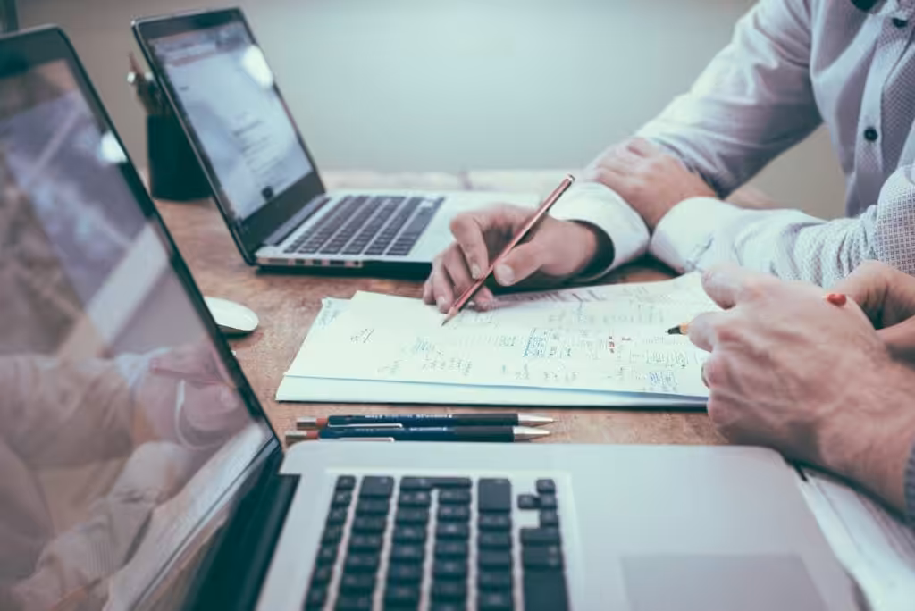 Project Manager holding pencil near laptop computer. Construction Contracts. Commercial Contract Law