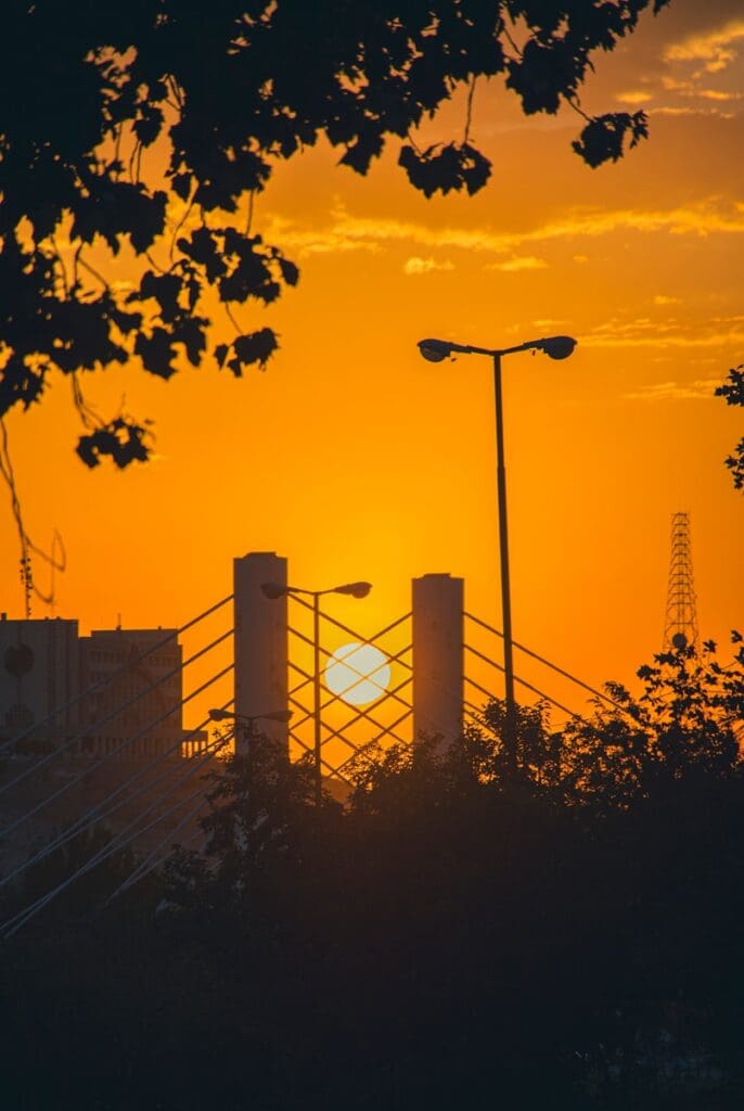 AS2124-1992 - Australian Standard Conditions of Contract for Construct Only Projects 18 A bridge with a sunset in the background. Aerial view of high-rise buildings. Indemnities, Insurances and Limits of Liability in Construction Contracts. Large Business. AS2124-1992. AS2124. Business Growth Strategist. Business Growth Strategies.