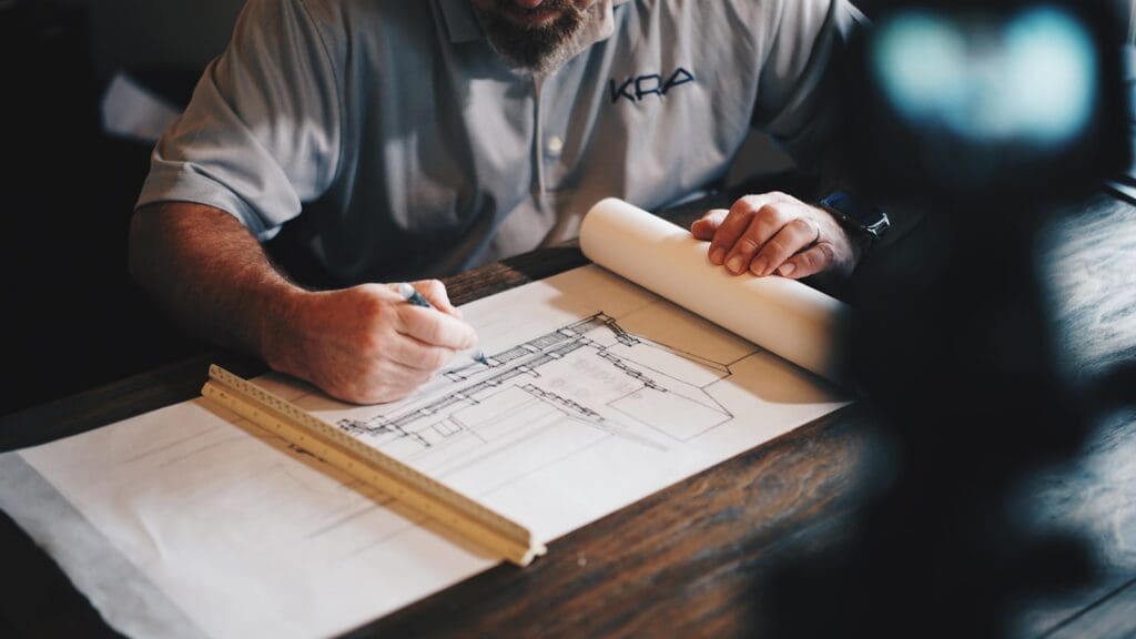 Construction Lawyers | Blaze Business & Legal 8 An architect working on a draft design with a pencil and ruler. Construction Lawyers