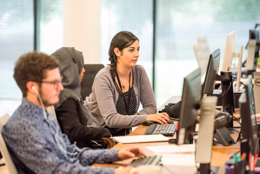 Employees working on computers. Small Business Management Consulting