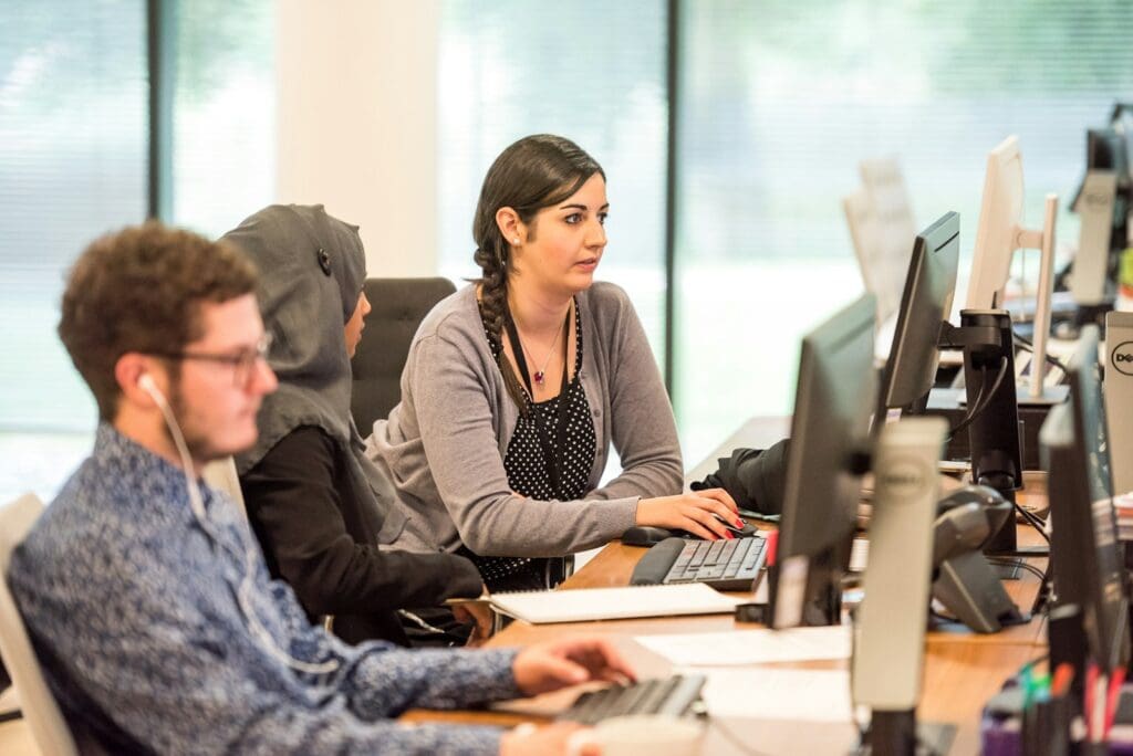 Transform Your Business in 2025 with our Small Business Management Consulting Services 2 Employees working on computers. Small Business Management Consulting