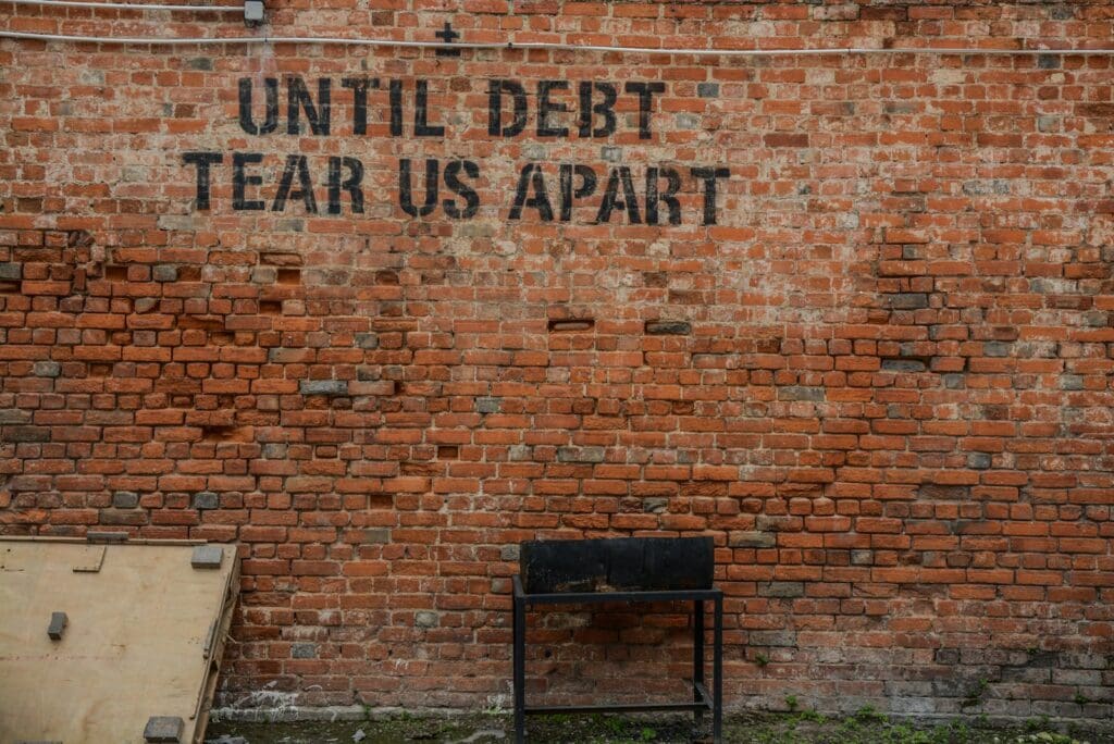 Business Loan Calculator - Should My Business Take Out A Loan? 9 Until debt tear us apart printed red brick wall. Business Loan Calculator