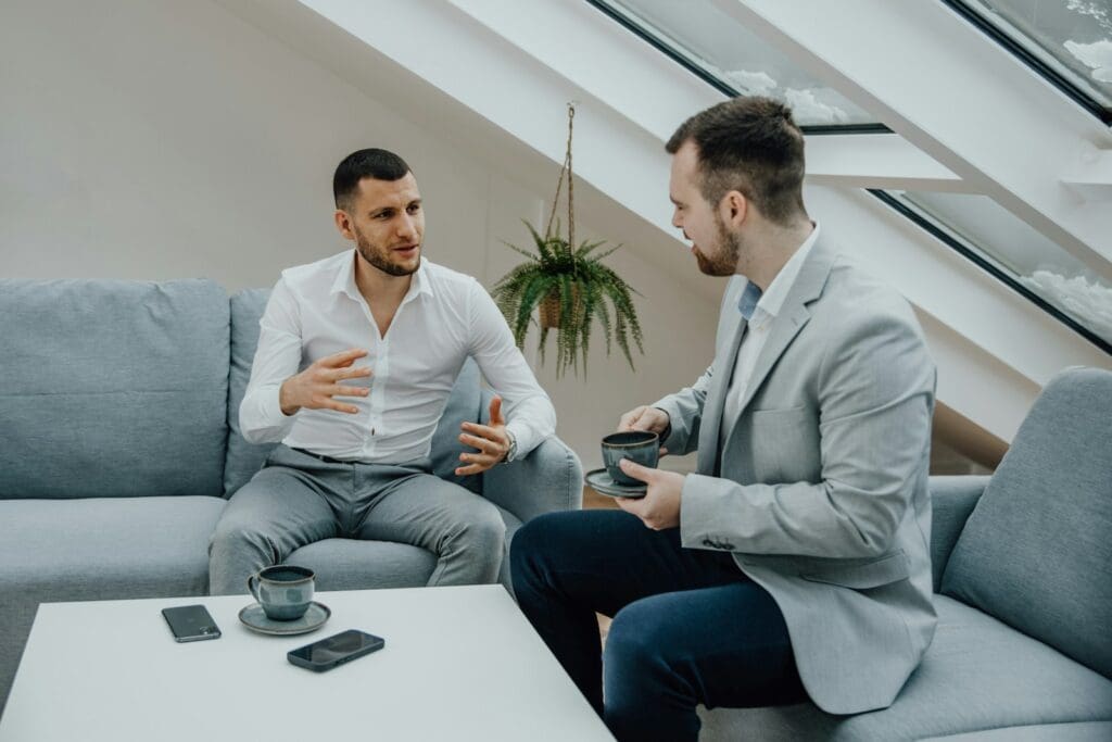 Legal Services 4 Commercial Lawyer and Business Consultant sitting on a couch talking to his client. Business Consulting at Blaze Business & Legal