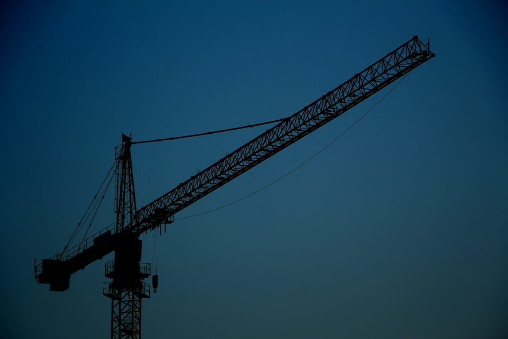 Legal Services 3 Black metal crane tower under blue sky. Construction Lawyer