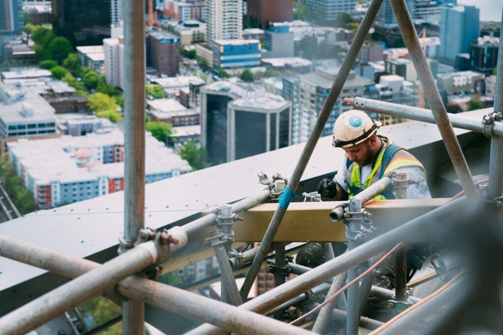 Expert Construction Lawyers Brisbane – Comprehensive Legal & Business Support 6 Man doing welding outdoors on a construction project. Time cost quality triangle. AS2124. Construction Lawyers Brisbane
