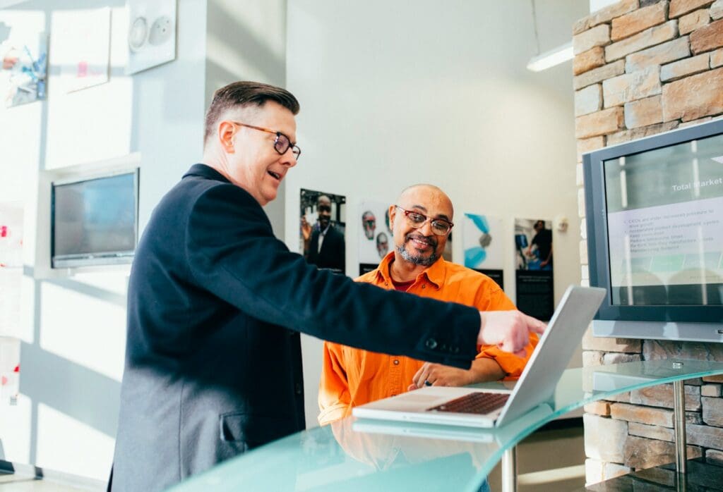 Business Loan Calculator - Should My Business Take Out A Loan? 2 Business owner speaking to a banker. Business Loan Calculator
