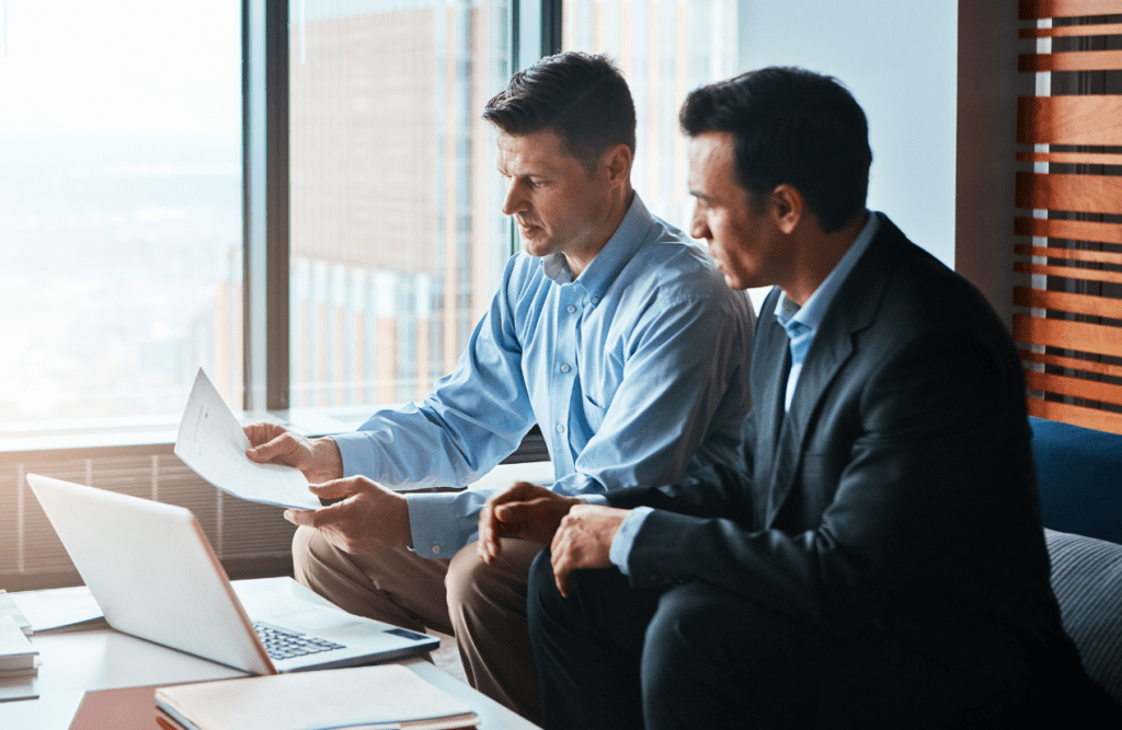 Leveraging Business Advice for Growth and Success (Our 10-point Roadmap in 2025) 3 Two business professionals holding and reviewing documents. Business Advice