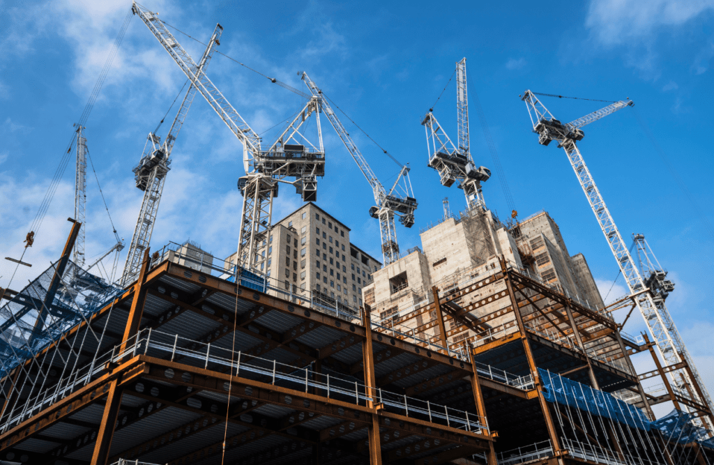 Construction cranes at work on a building site. Risk Management in Construction Projects. Security in construction contracts