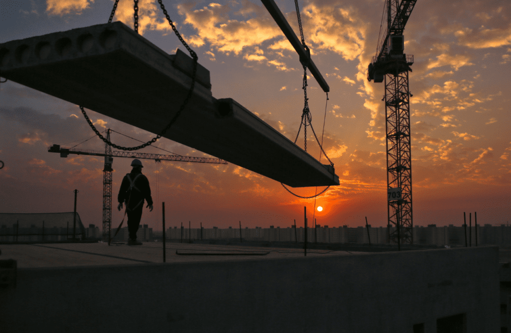 Construction Contract Review | Get Expert Legal Insights & Protect your Building Company 6 Construction worker wearing a safety harness and helmet stands on a building site. Risk Management in Construction Projects. Construction Contract Review