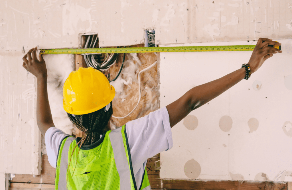 Construction worker measuring the wall. Risk Management in Construction Projects