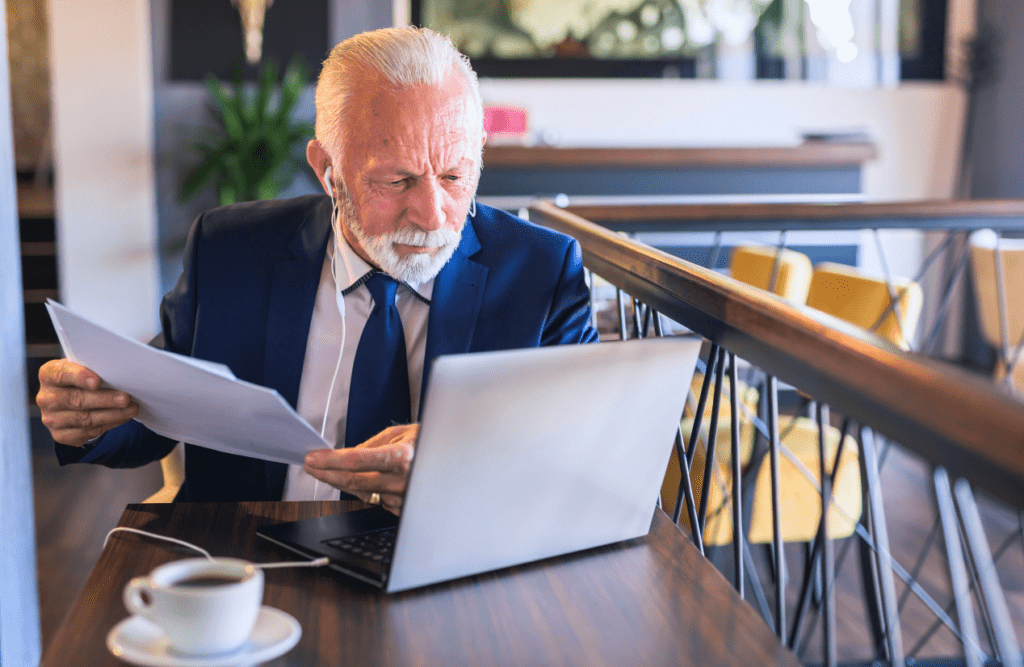 Blaze Business & Legal - How to Review a Contract 6 Businessman at a cafe holding a contract while looking at the laptop. How to Review a Contract