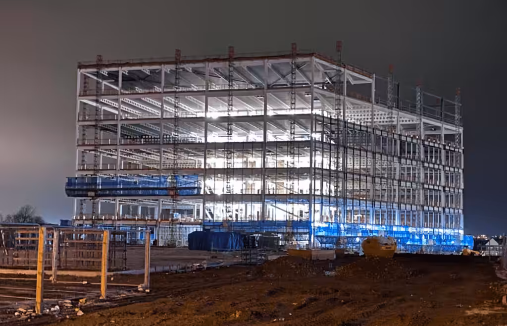 A large building under construction at night. DLP Meaning
