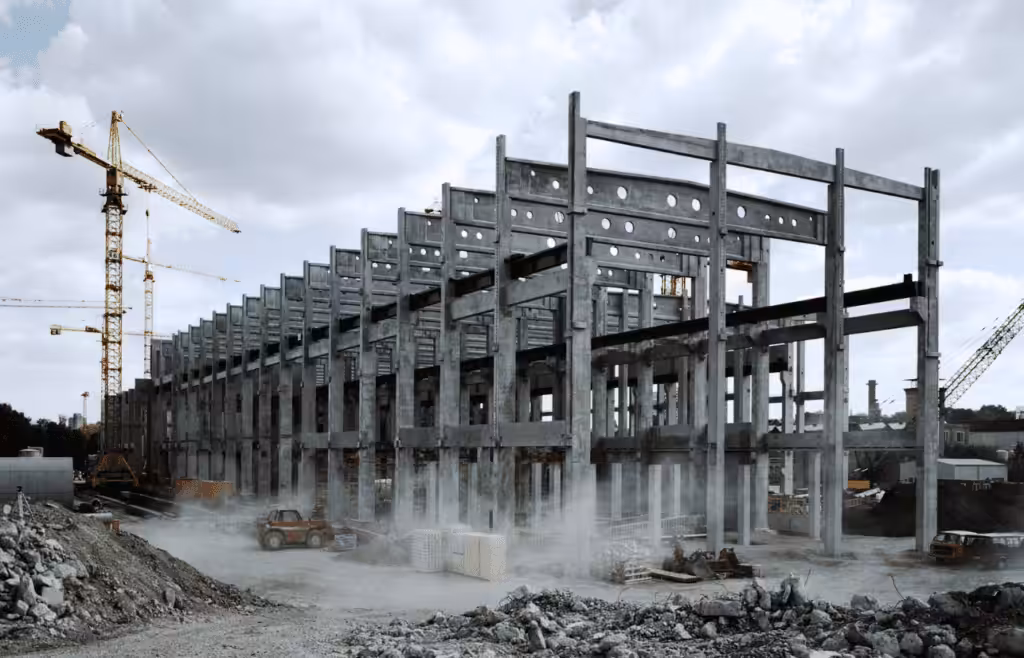 Construction site with concrete pillars and scaffolding surrounding the structure. DLP Meaning