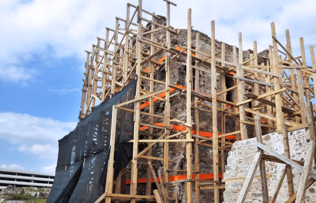 A building under construction with wooden scaffolding. DLP Meaning