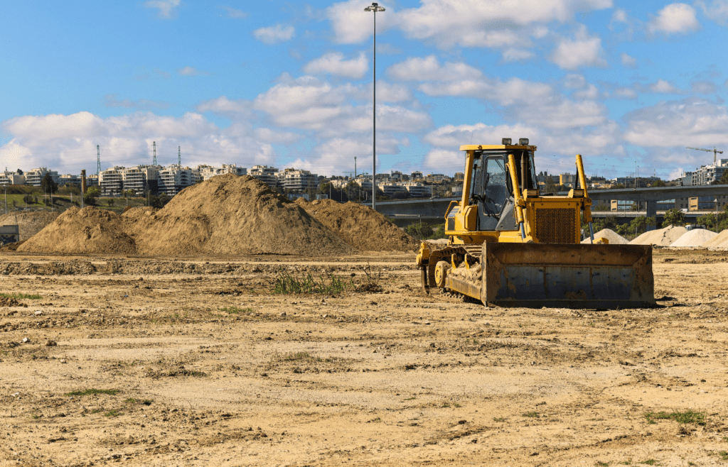 A bulldozer parked in a construction ground. Latent Conditions