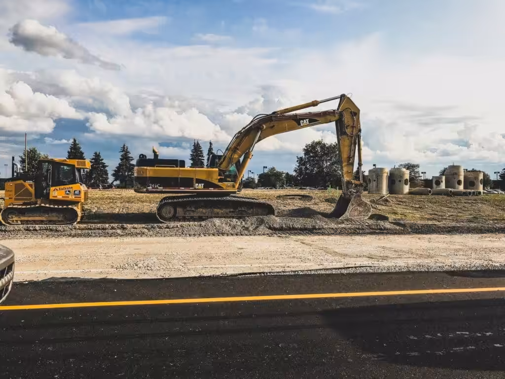 Yellow Caterpillar excavator digging up dirt. Extensions of Time. EOTs. EOT. Extension of Time.