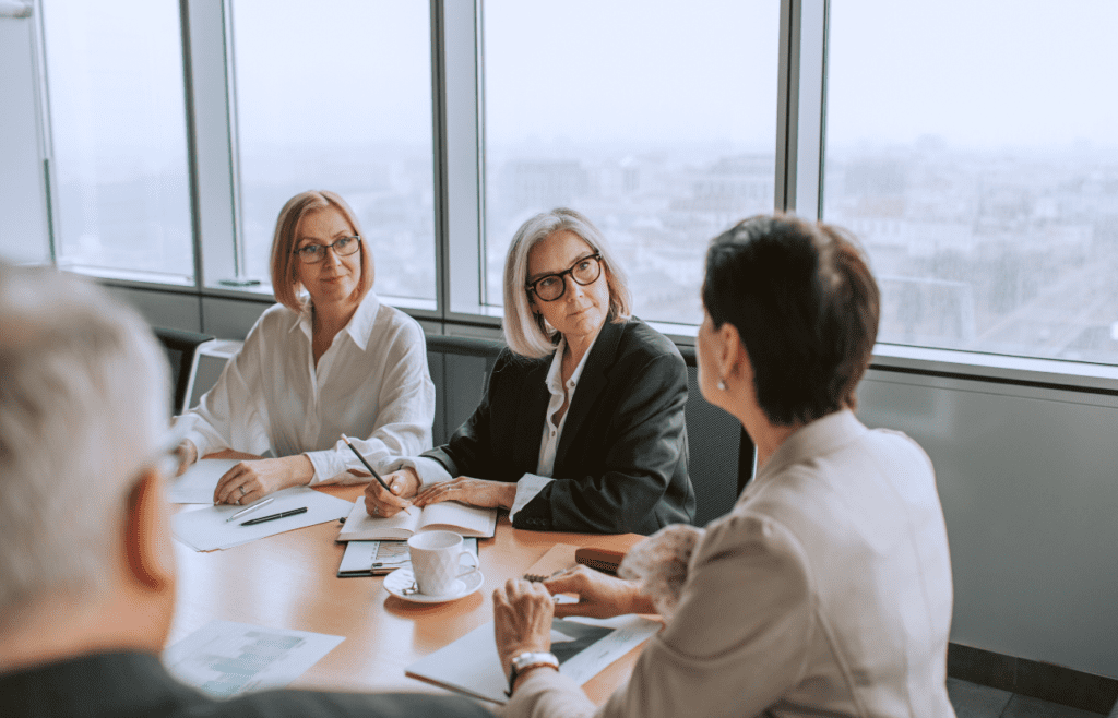 Business people seated at a conference table for a meeting. Management Consulting Companies Australia. Management Consulting Professional