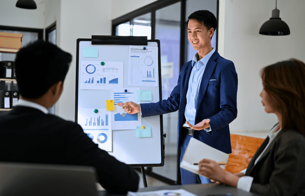 What is the Management Consulting Industry – A Practical Guide for Australian Businesses 18 Man delivers a presentation to his colleagues. Managment Consulting Industry