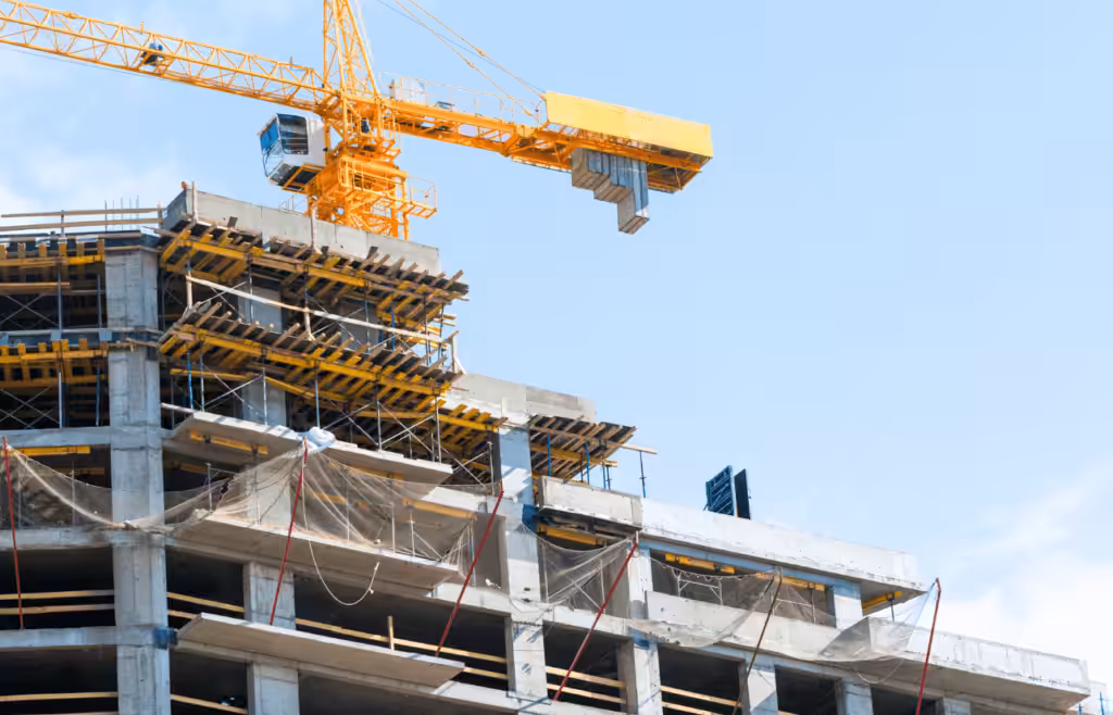 A construction crane positioned atop a partially built structure. Construction and Contracting
