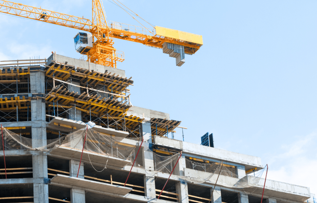 A construction crane positioned atop a partially built structure. Construction and Contracting