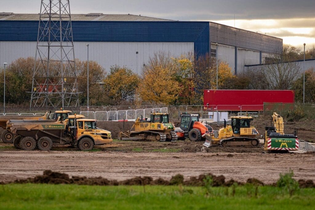 Construction equipment parked in front of a factory. Construction Industry Insights