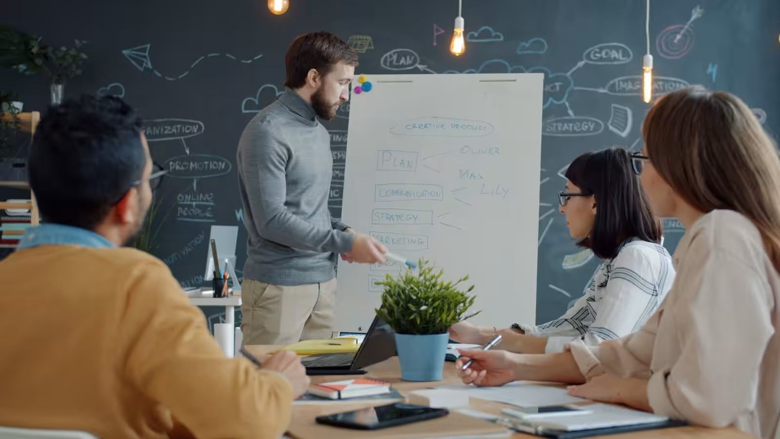 Team collaborating around a whiteboard in a construction business. Construction Business Improvement System