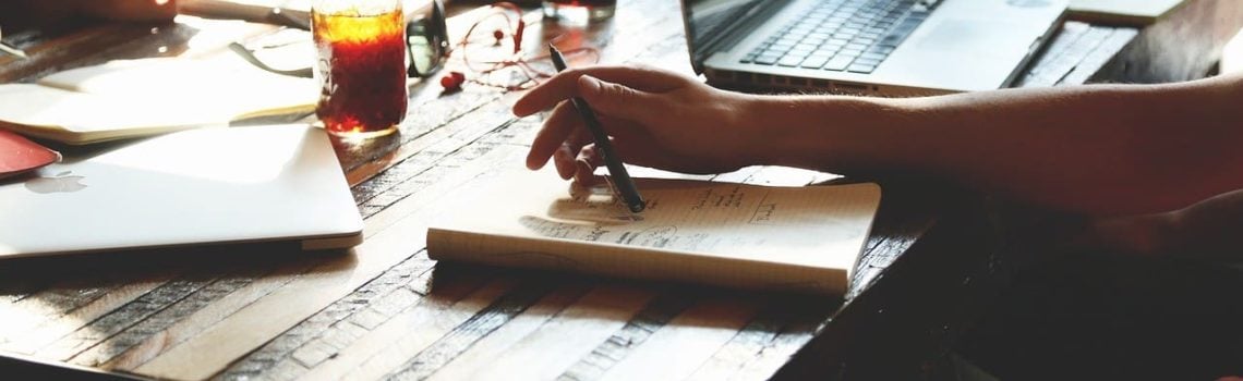 Business Consultant and client sitting at table with papers spread out. Small Business Management Consulting