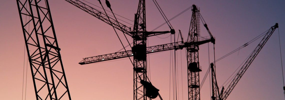Tower cranes during sunset. What is business advisory for construction businesses