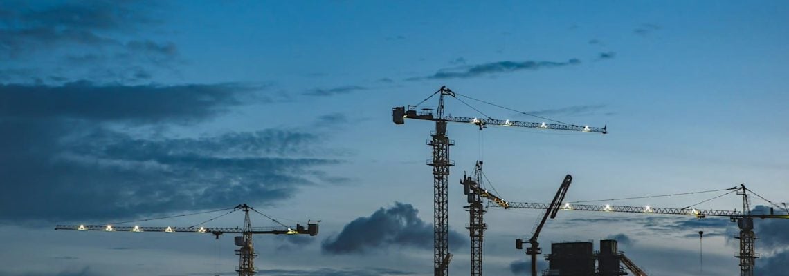 Cranes on a construction site above a building. Understanding the construct only contract. Construction Lawyer