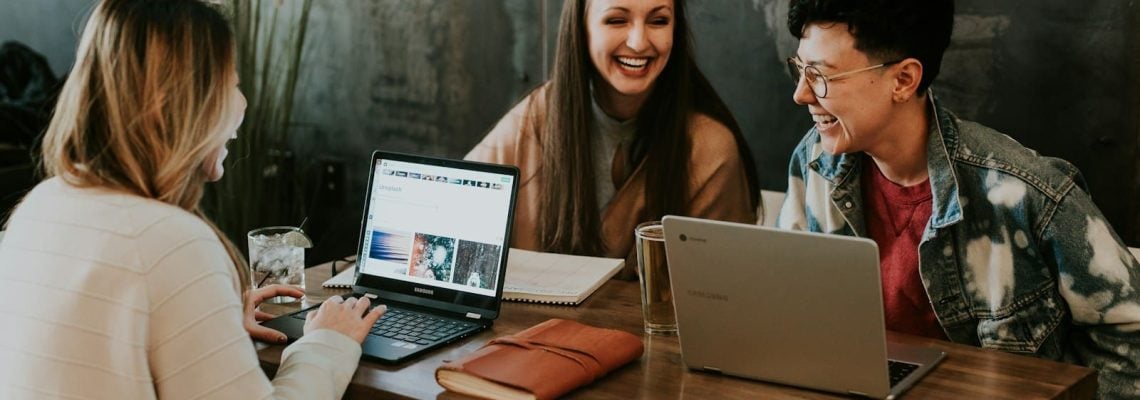 Consultants and clients sitting in front of a table laughing together. Small Business Management Consultant. Business Management Consulting. What is Business Advisory
