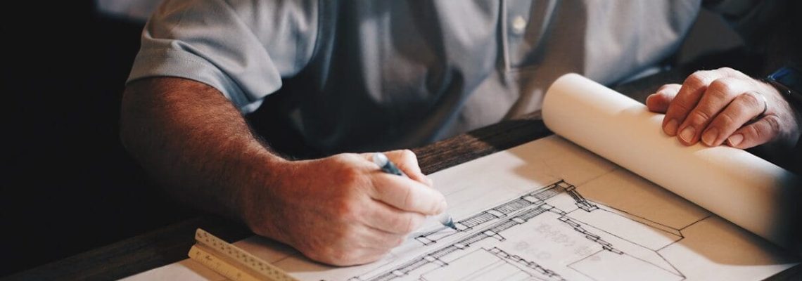 An architect working on a draft with a pencil and ruler. Design and construct vs Construct only An architect working on a draft with a pencil and ruler. Design and construct vs Construct only