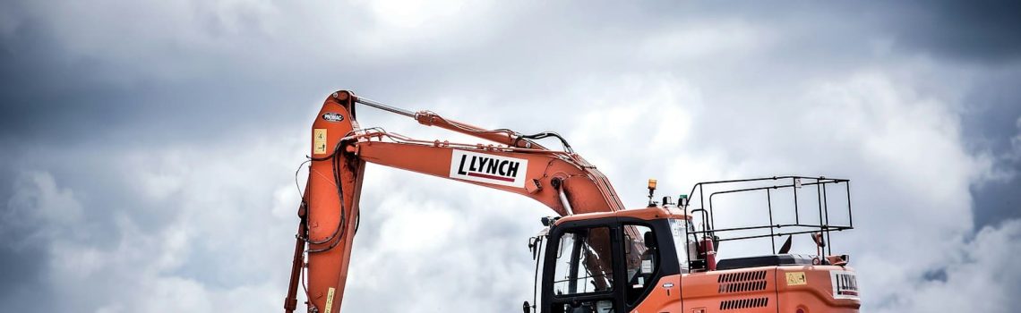 Orange excavator on a construction site. Construction Law. AS2124-1992. AS2124