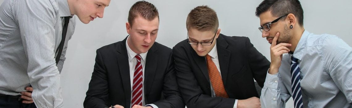 Four businessmen negotiating a contract. How to negotiate changes to a signed contract. Blaze Business & Legal