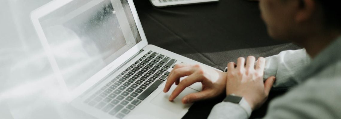 Owner of a construction company sitting in front of a laptop computer. What to look out for when reviewing a construction contract Owner of a construction company sitting in front of a laptop computer. What to look out for when reviewing a construction contract