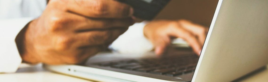 Person using laptop computer holding credit card. What to do when your business is losing money