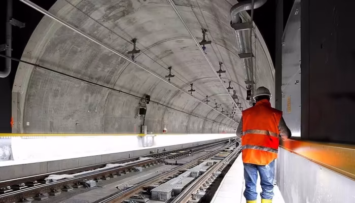 Man standing beside train rail inside a tunnel. AS4000-1997 Guide for Contractors. AS4000. Managing Contractor Contract. AS2124-1992. AS2124