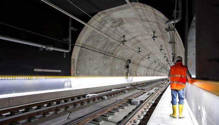 Man standing beside train rail inside a tunnel. AS4000-1997 Guide for Contractors. AS4000. Managing Contractor Contract. AS2124-1992. AS2124