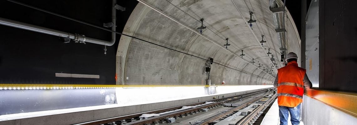 Man standing beside train rail inside a tunnel. AS4000-1997 Guide for Contractors. AS4000. Managing Contractor Contract. AS2124-1992. AS2124