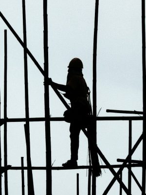 Worker climbing scaffolding. Construcction risk and construction risk management.